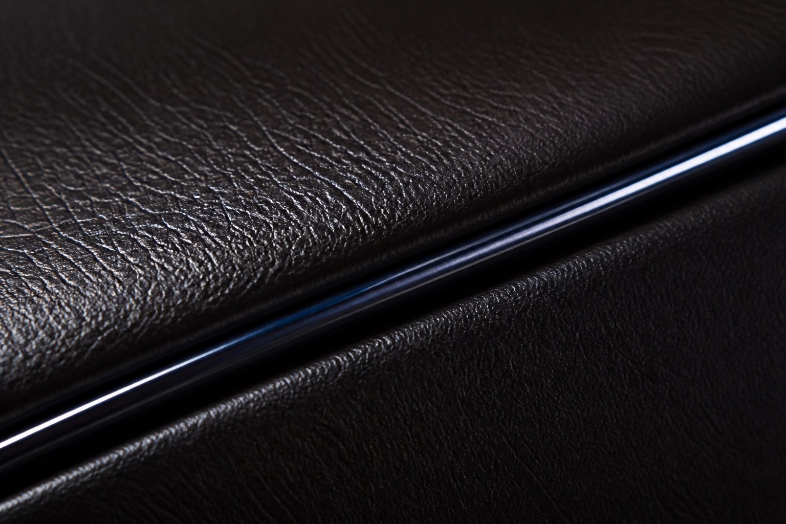 Dark polished leather grain with a chrome highlight